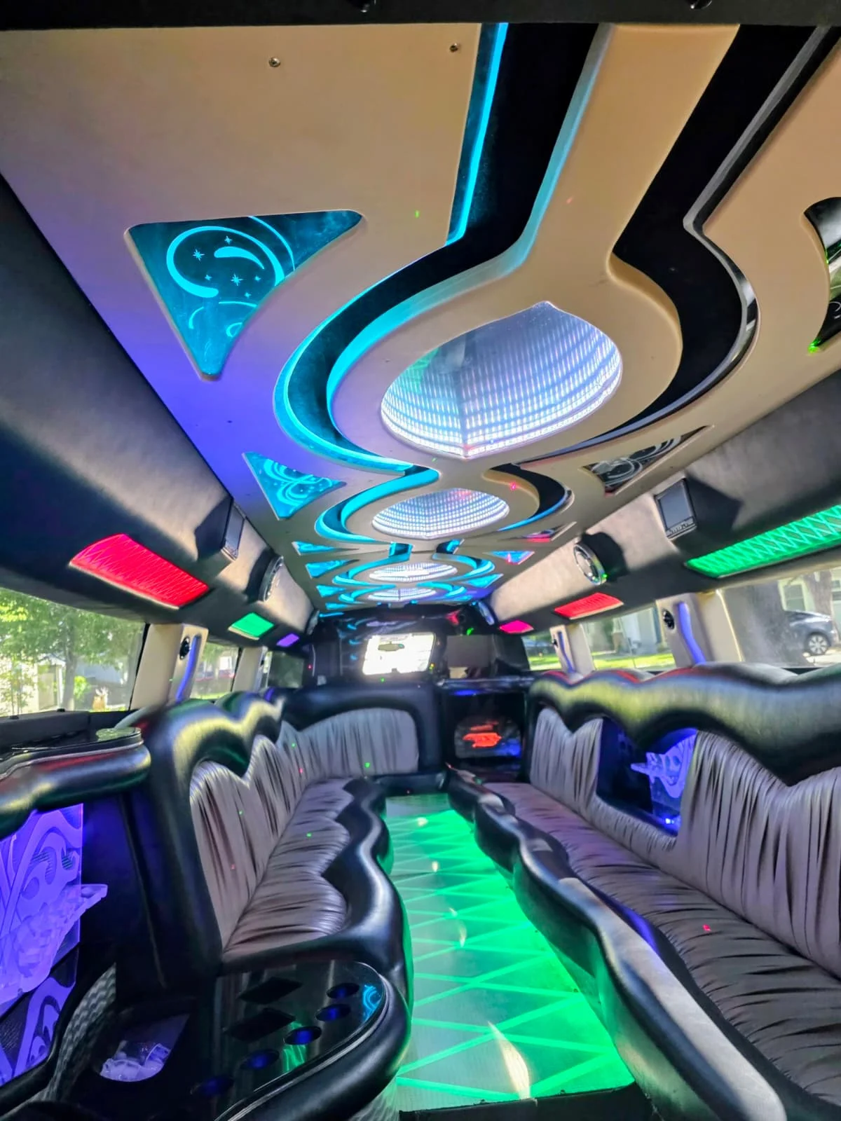 Hummer stretch limo interior with blue and teal LED mood lighting, green floor accent, black leather seating